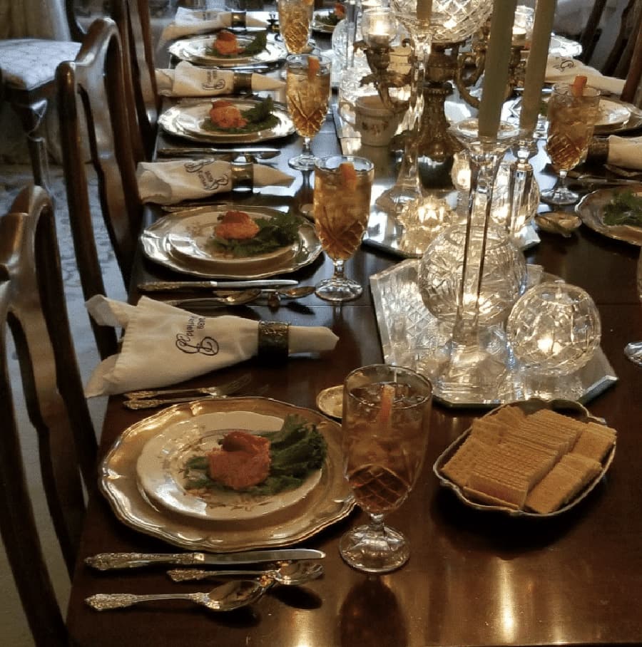 A beautifully set dining table with elegant dishes, crystal glasses, and lit candles.